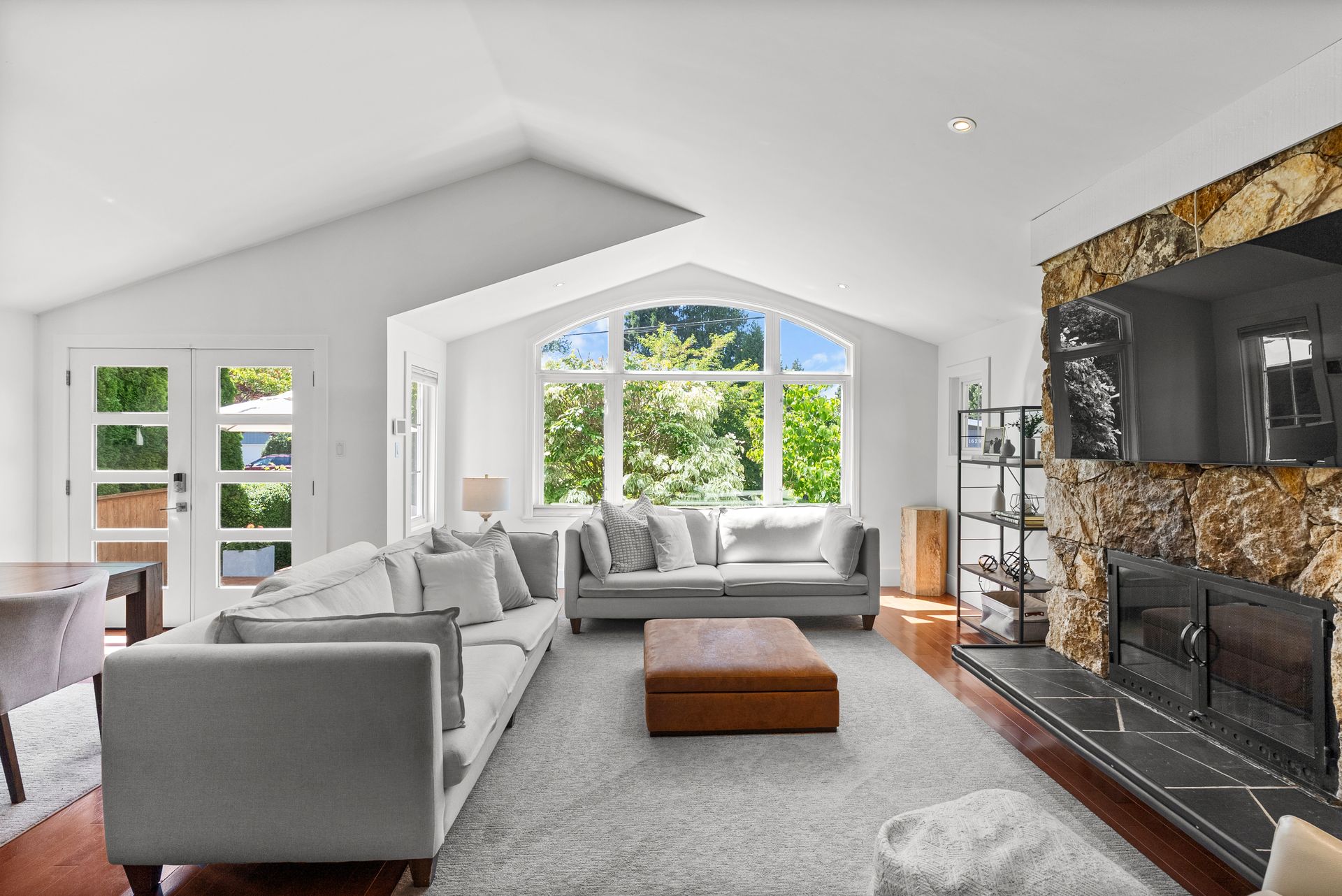 Vaulted living room with a stone fireplace