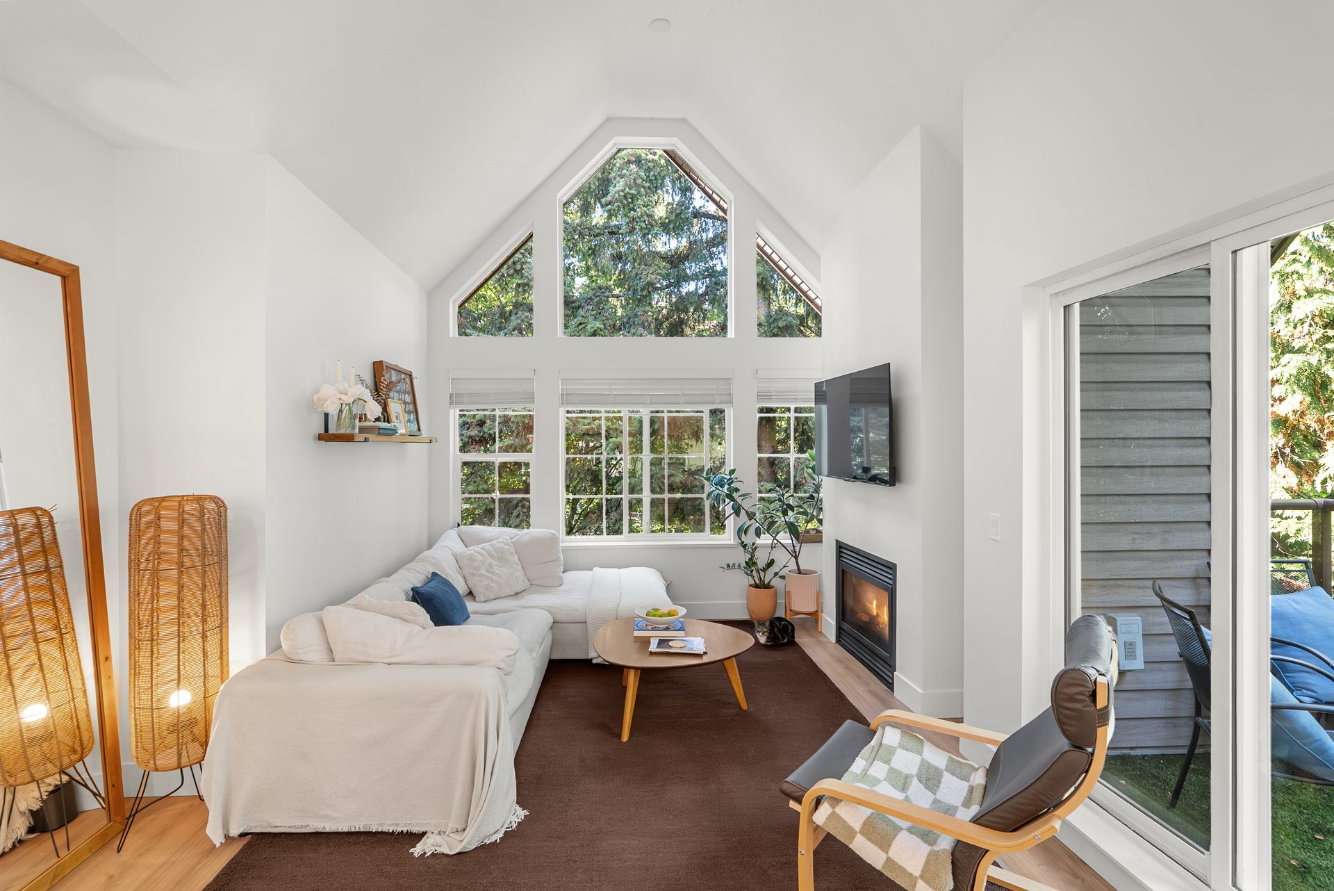 Living room with vaulted ceiling and tall windows